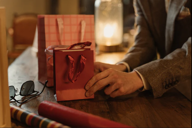 a man touching presents that are on a table