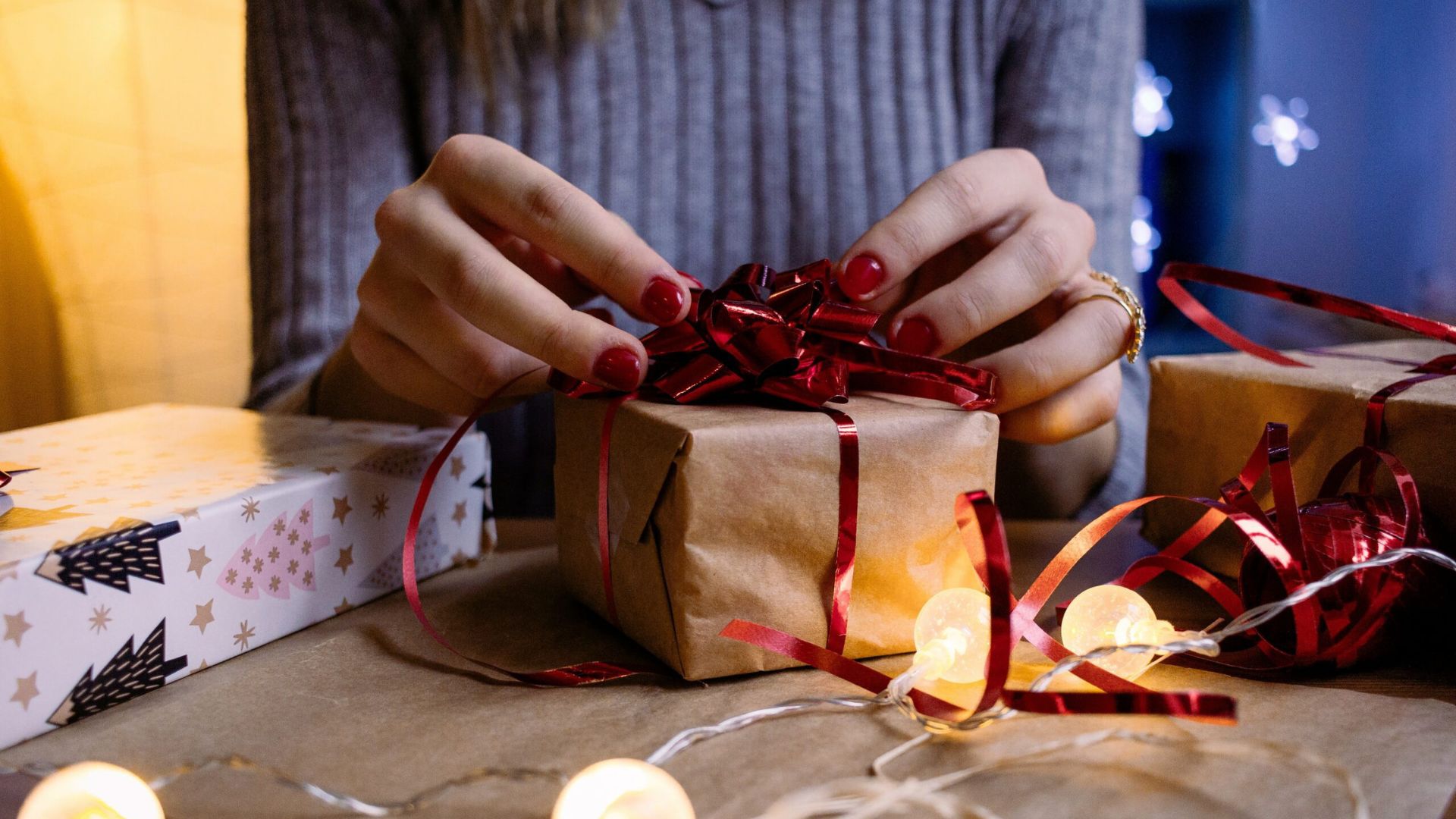 A Lady Opening a Box of Gifts Showing The Most Popular Gifts Given on Christmas in the US